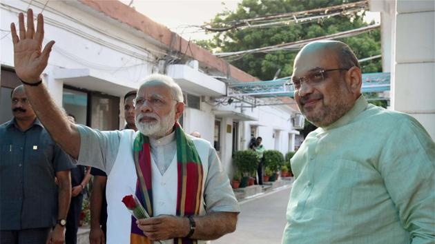 Prime Minister Narendra Modi waves at supporters as BJP President Amit Shah looks on, prior to a meeting with chief ministers of BJP-ruled states in New Delhi.(PTI FILE PHOTO)