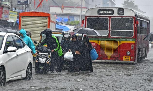 People and motorists wade through knee-deep water at Andheri during the downpour on August 29.(HT Photo)