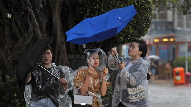 In this August 27, 2017, file photo, people hold umbrellas against the strong wind caused by tropical storm Pakhar near the waterfront of Victoria Harbor in Hong Kong. (AP Photo) In this August 27, 2017, file photo, people hold umbrellas against the strong wind caused by tropical storm Pakhar near the waterfront of Victoria Harbor in Hong Kong. (AP Photo)