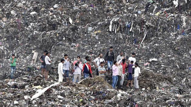 People gathered at the garbage mound in east Delhi’s Ghazipur. A part of this ‘trash mountain’ collapsed into a canal on September 1 killing two persons.(Mohd Zakir/ HT Photo)