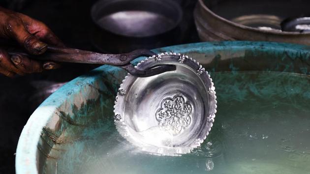 With the patina renewed, the still simmering utensil is then doused in plain water, the sudden impact solidifying its fresh tin coat. This process brings out the ‘tin-cry’ -a shrill sound characteristic of the metallic reaction that dims once the temperature returns to safe handling levels. (Mohd Zakir / HT Photo) With the patina renewed, the still simmering utensil is then doused in plain water, the sudden impact solidifying its fresh tin coat. This process brings out the ‘tin-cry’ -a shrill sound characteristic of the metallic reaction that dims once the temperature returns to safe handling levels. (Mohd Zakir / HT Photo)
