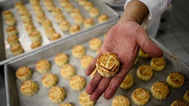 Chef Yip Wing-wah displays his freshly oven-baked signature “spring moon mini egg custard mooncakes” at Hong Kong’s famous colonial era Peninsula Hotel. (AFP) Chef Yip Wing-wah displays his freshly oven-baked signature “spring moon mini egg custard mooncakes” at Hong Kong’s famous colonial era Peninsula Hotel. (AFP)