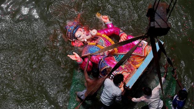 Devotees immerse an idol of the Ganesh into the Sabarmati river on the last day of the Ganesh Chaturthi festival in Ahmedabad on September 5. (REUTERS) Devotees immerse an idol of the Ganesh into the Sabarmati river on the last day of the Ganesh Chaturthi festival in Ahmedabad on September 5. (REUTERS)