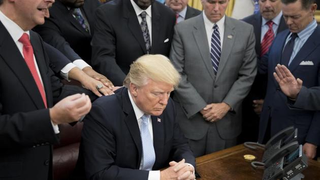 President Donald Trump during a group prayer in the Oval Office at the White House in Washington on Sunday.(NYT Photo) President Donald Trump during a group prayer in the Oval Office at the White House in Washington on Sunday.(NYT Photo)