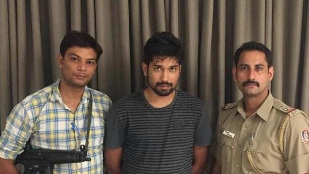 Rishi Kapoor (centre), who allegedly cheated clients on online portals with fake bank messages, in police custody.(Pic provided by Delhi Police)