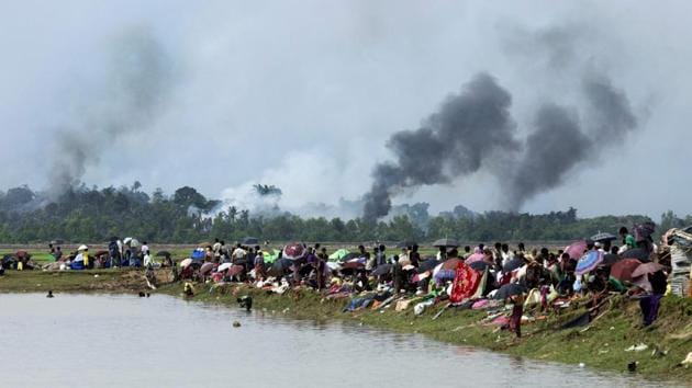 Smoke billows above what is reported to be a burning village in Myanmar's Rakhine state as members of the Rohingya Muslim minority take shelter in a no-man's land between Bangladesh and Myanmar in Ukhiya on September 4, 2017. Almost 15,000 Rohingya refugees are estimated to cross the Naf river into Bangladesh each day this week, scrambling for shelter in overcrowded camps and makeshift settlements. (K. M. Asad / AFP) Smoke billows above what is reported to be a burning village in Myanmar's Rakhine state as members of the Rohingya Muslim minority take shelter in a no-man's land between Bangladesh and Myanmar in Ukhiya on September 4, 2017. Almost 15,000 Rohingya refugees are estimated to cross the Naf river into Bangladesh each day this week, scrambling for shelter in overcrowded camps and makeshift settlements. (K. M. Asad / AFP)