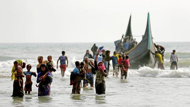 Rohingya refugees walk to the shore after crossing the Bangladesh-Myanmar border by boat through the Bay of Bengal in Teknaf, Bangladesh, September 5, 2017. At least five children were killed when several boats carrying Rohingya refugees from Myanmar sank early Wednesday, Bangladesh border guards told AFP. Deaths among refugees resulting from boats capsizing were also reported earlier this week killing 26. (Mohammad Ponir Hossain / Reuters) Rohingya refugees walk to the shore after crossing the Bangladesh-Myanmar border by boat through the Bay of Bengal in Teknaf, Bangladesh, September 5, 2017. At least five children were killed when several boats carrying Rohingya refugees from Myanmar sank early Wednesday, Bangladesh border guards told AFP. Deaths among refugees resulting from boats capsizing were also reported earlier this week killing 26. (Mohammad Ponir Hossain / Reuters)