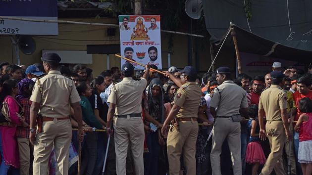 Police personnel control the crowd during Ganesh visarjan procession in Pune on Tuesday.  (Pratham Gokhale/HT PHOTO) 