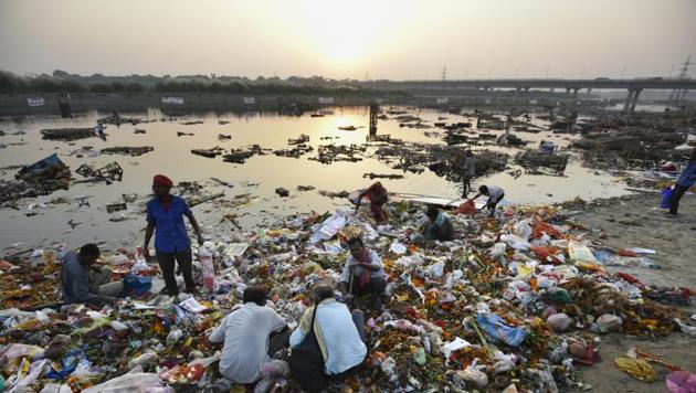 Locals scavenge for the remains of idols in the Yamuna after Durga Puja in New Delhi on October 12, 2016.(Ravi Choudhary/HT File Photo)