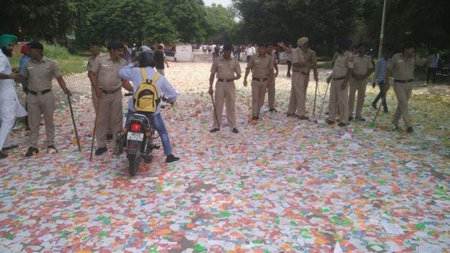 Police security personnel stand upon a sea of stickers outside DAV College, Sector 10, on Thursday.   (Karun Sharma/HT) 