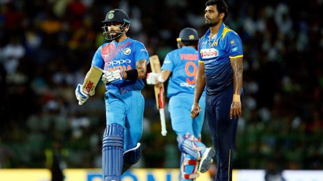 Virat Kohli runs between wickets next to Sri Lanka's Thisara Perera during the one-off T20 in Colombo on Wednesday. India won by seven wickets.(REUTERS)