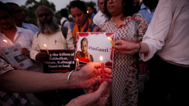 People hold placards and candles during a vigil for Gauri Lankesh in New Delhi. (REUTERS) People hold placards and candles during a vigil for Gauri Lankesh in New Delhi. (REUTERS)