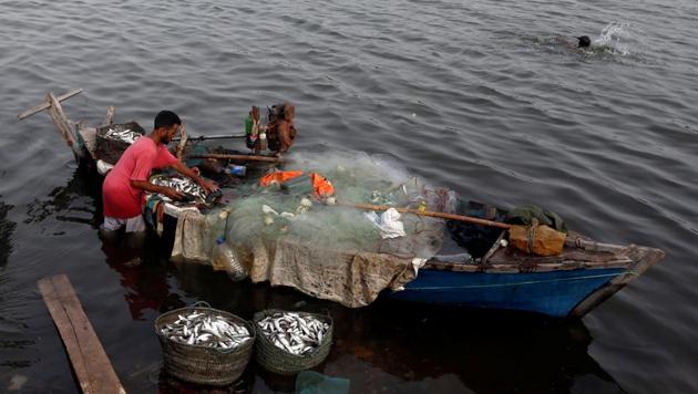 A fisherman unloads baskets of fish from a boat after he returned from a day catch, along China Creek area of Karachi on July 3. (REUTERS)