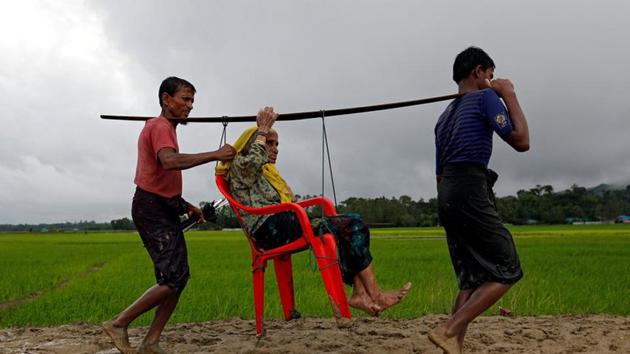Rohingya refugee men carry an old woman as she is unable to walk after crossing the border in Teknaf, Bangladesh, on September 1, 2017.(Reuters)