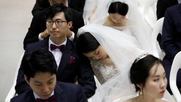 A bride naps as newlywed couples attend the mass wedding ceremony on September 7, 2017. Escaping during the Korean War, Moon founded the church in the South in 1954, proclaiming himself a messiah. The church now claims around three million members worldwide. (Kim Hong-Ji / REUTERS) A bride naps as newlywed couples attend the mass wedding ceremony on September 7, 2017. Escaping during the Korean War, Moon founded the church in the South in 1954, proclaiming himself a messiah. The church now claims around three million members worldwide. (Kim Hong-Ji / REUTERS)