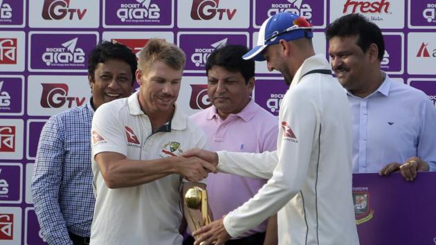 Australia's David Warner and Nathan Lyon hold the men of the series trophy jointly during a presentation ceremony after the second Test match vs Bangladesh.(AP)