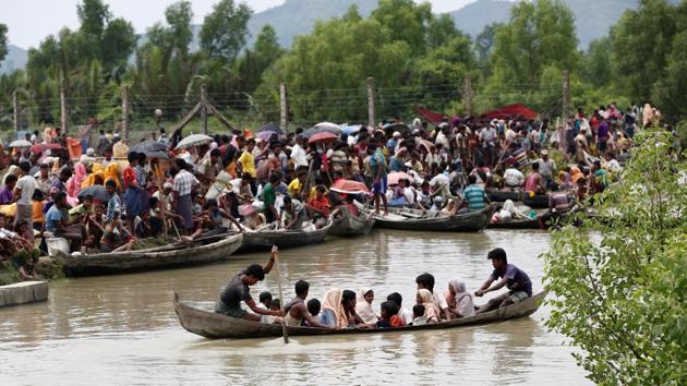 A boat carrying Rohingya refugees is seen leaving Myanmar through Naf river while thousands other wait in Maungdaw on Thursday.(Reuters photo)