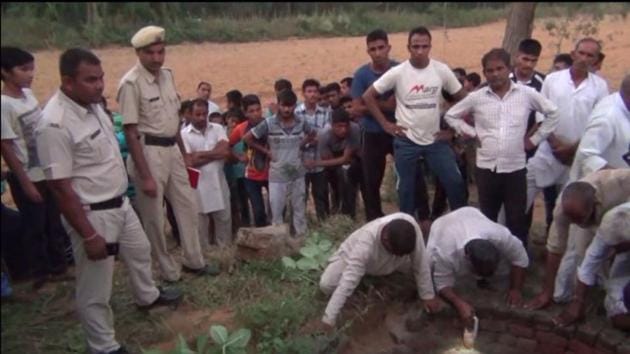 Police assisting villagers in pulling out body of Sombir, who allegedly committed suicide by jumping into a well.(HT Photo)