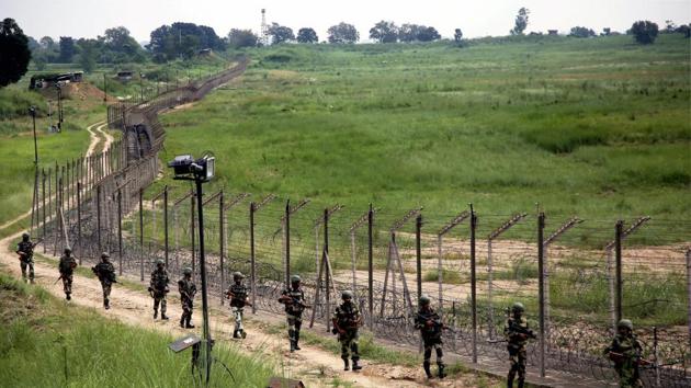 Indian security personnel patrol the fence along the international border. Pakistan fired at Indian positions in Poonch district on Saturday.(PTI)