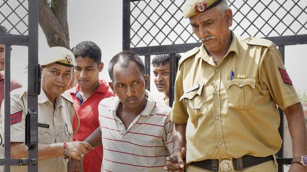 Bus conductor Ashok Kumar being escorted by police.(Sanjeev Verma/HT Photo)