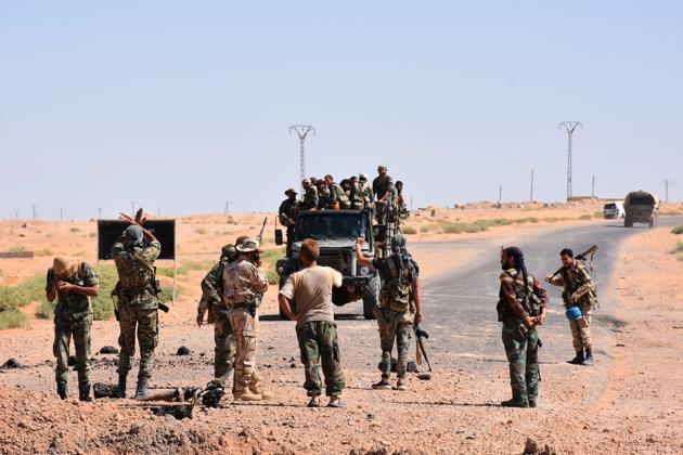 Syrian government forces gesture and inspect the site as they arrive to a destroyed bridge on a road between the Kabajeb and Al-Shula on the southwestern outskirts of Deir Ezzor on September 8, 2017, during the ongoing battle against Islamic State (IS) group jihadists.(AFP)