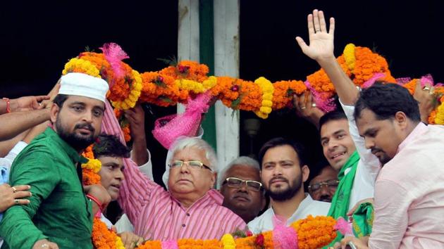 RJD chief Lalu Prasad with leader of opposition in Bihar assembly Tejashwi Yadav being garlanded by the supporters during a rally against Sirjan Scam in Bhagalpur district on Sunday.(PTI Photo)