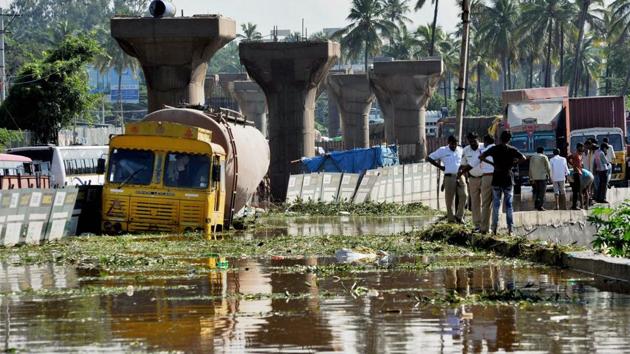 A lorry stuck at a waterlogged road near the metro construction site in Kengeri in Bengaluru on Sunday following rains. (PTI Photo) A lorry stuck at a waterlogged road near the metro construction site in Kengeri in Bengaluru on Sunday following rains. (PTI Photo)