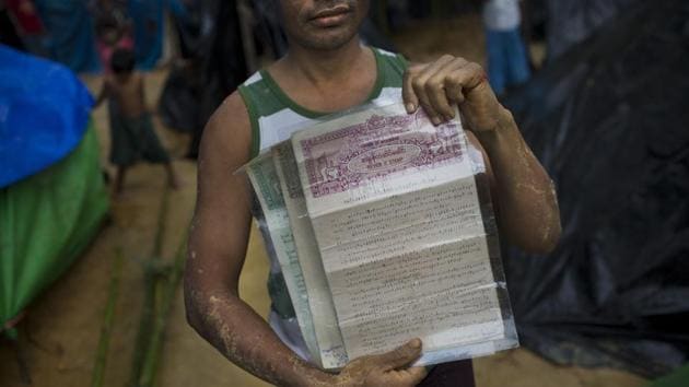 Nur Bashar a Rohingya refugee, holds documents of property and land his family owns in Myanmar. Many bring documents from their life back in Myanmar, laminated to protect them from the rain. National or school ID cards and scraps that prove that even their grandparents lived in that country. One family brought property records, proof of a parcel of land they bought in 1994. Also proof of their desire to one day return to the place they still call home. (Bernat Armangue / AP) Nur Bashar a Rohingya refugee, holds documents of property and land his family owns in Myanmar. Many bring documents from their life back in Myanmar, laminated to protect them from the rain. National or school ID cards and scraps that prove that even their grandparents lived in that country. One family brought property records, proof of a parcel of land they bought in 1994. Also proof of their desire to one day return to the place they still call home. (Bernat Armangue / AP)
