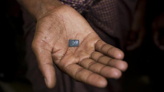 A Rohingya refugee displays a memory card carried across from Myanmar into Bangladesh. Those who don’t carry cellphones still often bring memory cards from their abandoned phones. Some Rohingya said they erased personal photos and videos because they were afraid that Myanmar soldiers would use them to find and persecute their families still behind. With access to internal media restricted, memory cards and cellphones are invaluable at getting information out of Myanmar. (Bernat Armangue / AP) A Rohingya refugee displays a memory card carried across from Myanmar into Bangladesh. Those who don’t carry cellphones still often bring memory cards from their abandoned phones. Some Rohingya said they erased personal photos and videos because they were afraid that Myanmar soldiers would use them to find and persecute their families still behind. With access to internal media restricted, memory cards and cellphones are invaluable at getting information out of Myanmar. (Bernat Armangue / AP)