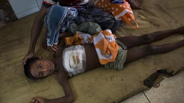 Shoabib, 7, lies on the floor next to his father at Sadar Hospital in Cox’s Bazar, Bangladesh, Sunday.(AP)