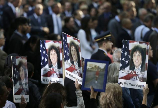 People hold up signs with the names and pictures of victims of the 9/11 terrorist attacks during a ceremony at ground zero in New York. Nearly 3,000 people died when hijacked planes slammed into the trade center, the Pentagon and a field near Shanksville, Pennsylvania, on September 11, 2001, hurling America into a new consciousness of the threat of global terrorism. (Seth Wenig / AP) People hold up signs with the names and pictures of victims of the 9/11 terrorist attacks during a ceremony at ground zero in New York. Nearly 3,000 people died when hijacked planes slammed into the trade center, the Pentagon and a field near Shanksville, Pennsylvania, on September 11, 2001, hurling America into a new consciousness of the threat of global terrorism. (Seth Wenig / AP)