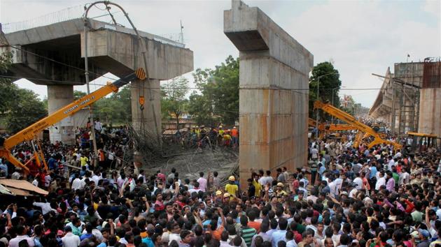 People gather near the site of mishap where an under-construction ovebridge collapsed at Bomikhal in Bhubaneswar on Sunday.(PTI)
