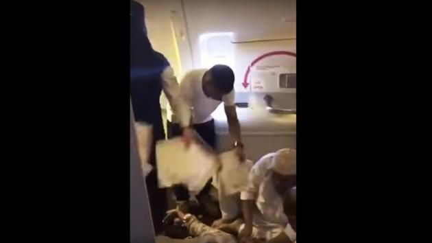 Passengers help a fellow traveller who fainted onboard the Karachi-bound flight from Saudi Arabia. (Photo: Twitter)