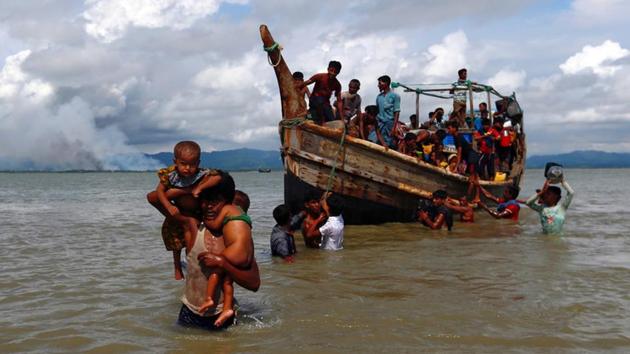 Smoke is seen on Myanmar's side of the border as Rohingya refugees get off a boat after crossing the Bangladesh-Myanmar border through the Bay of Bengal in Shah Porir Dwip on September 11, 2017. (Reuters) Smoke is seen on Myanmar's side of the border as Rohingya refugees get off a boat after crossing the Bangladesh-Myanmar border through the Bay of Bengal in Shah Porir Dwip on September 11, 2017. (Reuters)