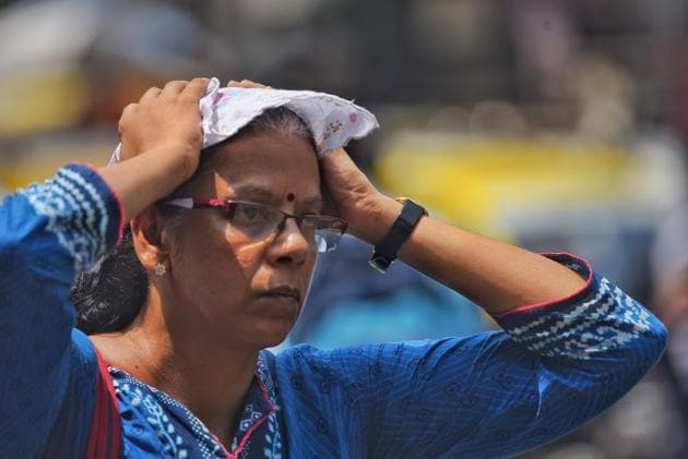 A woman tries to protect her head from the heat at Dadar.(Pratik Chorge/HT Photo)