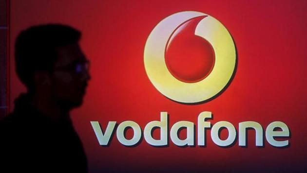 A man casts silhouette onto an electronic screen displaying logo of Vodafone India.(Reuters File Photo)