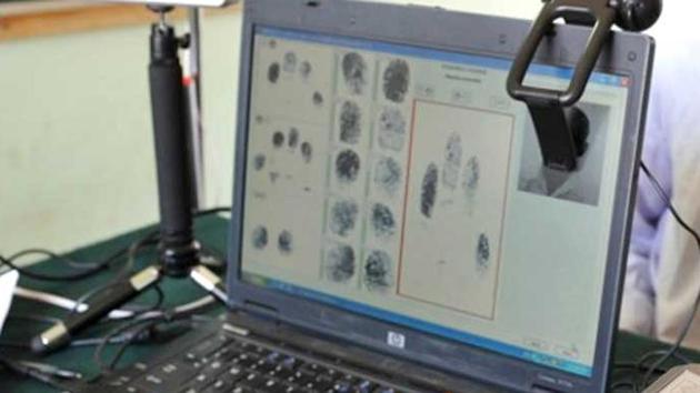 A man looks on as another puts his hand on a 'Slap Pad' for recording of fingerprints during the data collecting process for a pilot project of Unique Identification Authority of . (AFP File Photo) A man looks on as another puts his hand on a 'Slap Pad' for recording of fingerprints during the data collecting process for a pilot project of Unique Identification Authority of . (AFP File Photo)