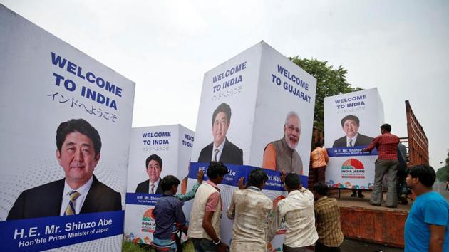 Workers carry a hoarding featuring Prime Minister Narendra Modi and his Japanese counterpart Shinzo Abe to load it onto a truck ahead of Abe's visit, in Ahmedabad on September 10.(REUTERS) Workers carry a hoarding featuring Prime Minister Narendra Modi and his Japanese counterpart Shinzo Abe to load it onto a truck ahead of Abe's visit, in Ahmedabad on September 10.(REUTERS)