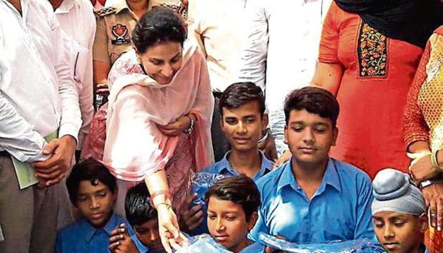 Former Union minister Preneet Kaur distributing uniforms and books among students at Ablowal school in Patiala.(HT Photo)