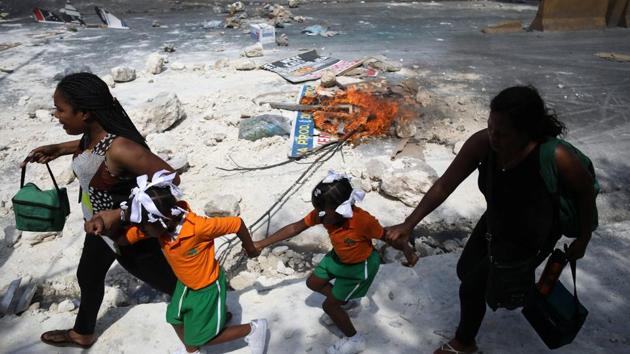 Two women and two girls walk past a barricade during a demonstration against the government in Port-au-Prince, Haiti. Meanwhile, if providing an income tax certificate is needed for administrative tasks such as renewing a license, a 10,000-gourde payment will only be required from those earning more than 60,000 gourdes a year. Officials hope the move will encourage more Haitians to declare their income. (Andres Martinez Casares / REUTERS) Two women and two girls walk past a barricade during a demonstration against the government in Port-au-Prince, Haiti. Meanwhile, if providing an income tax certificate is needed for administrative tasks such as renewing a license, a 10,000-gourde payment will only be required from those earning more than 60,000 gourdes a year. Officials hope the move will encourage more Haitians to declare their income. (Andres Martinez Casares / REUTERS)