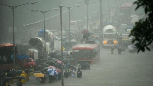 People wade along a flooded street during heavy rain showers in Mumbai on August 29, 2017. Heavy rain brought India's financial capital Mumbai to a virtual standstill on August 29, flooding streets, causing transport chaos and prompting warnings to stay indoors. Dozens of flights and local train services were cancelled as rains lashed the coastal city of nearly 20 million people. / AFP PHOTO / PUNIT PARANJPE (AFP File Photo) People wade along a flooded street during heavy rain showers in Mumbai on August 29, 2017. Heavy rain brought India's financial capital Mumbai to a virtual standstill on August 29, flooding streets, causing transport chaos and prompting warnings to stay indoors. Dozens of flights and local train services were cancelled as rains lashed the coastal city of nearly 20 million people. / AFP PHOTO / PUNIT PARANJPE (AFP File Photo)