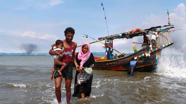Smoke is seen on Myanmar's side of border as Rohingya refugees get off from a boat after crossing the Bangladesh-Myanmar border through the Bay of Bengal in Shah Porir Dwip on September 15, 2017. (Reuters) Smoke is seen on Myanmar's side of border as Rohingya refugees get off from a boat after crossing the Bangladesh-Myanmar border through the Bay of Bengal in Shah Porir Dwip on September 15, 2017. (Reuters)