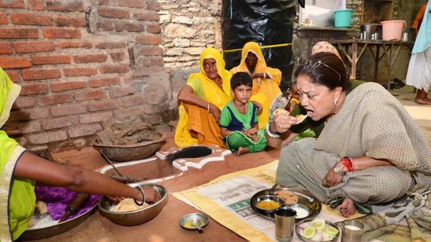 Chief minister Vasundhara Raje having lunch at a Dalit home in Matunda on Friday.(HT Photo)