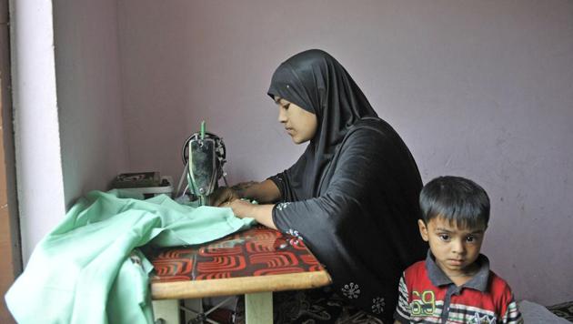 Yasmeen, a Rohingya refugee from Myanmar, stitches clothes inside a house on the outskirts of Srinagar.(Waseem Andrabi/HT Photo)