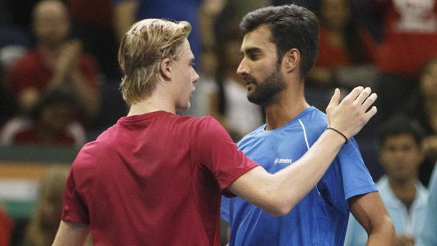 Denis Shapovalov is congratulated by Yuki Bhambri after his 7-6(2), 6-4, 6-7(8), 4-6, 6-1 win. (AP)
