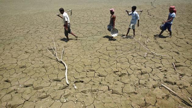 Labourers walk through parched land in Tripura. India’s most important food crop producing states are staring at a drought-like situation.(REUTERS / Representational Photo)