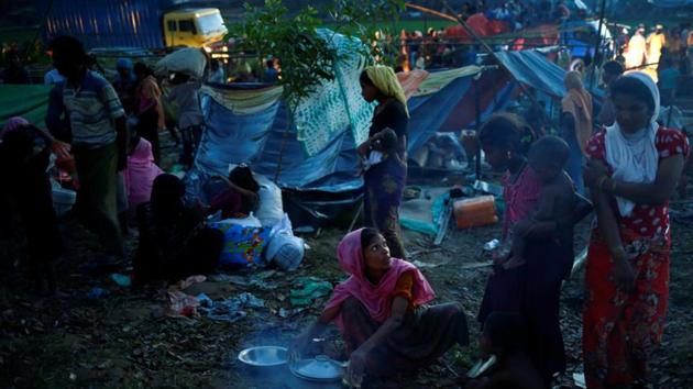 A Rohingya refugee woman interacts with a girl while cooking her meal in a newly built makeshift camp, in Cox's Bazar, Bangladesh on September 15. (REUTERS) A Rohingya refugee woman interacts with a girl while cooking her meal in a newly built makeshift camp, in Cox's Bazar, Bangladesh on September 15. (REUTERS)