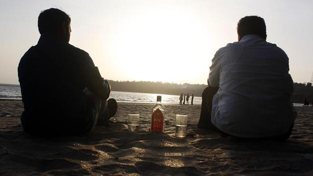 Tourists enjoy a drink of Goa’s local alcoholic beverage, Feni, at Bambolim beach.(HT File Photo)