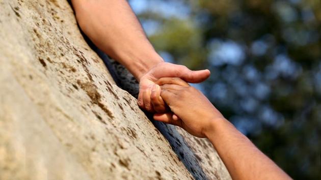 Lending a helping hand to a partner in mountains. (Getty Images/iStockphoto) Lending a helping hand to a partner in mountains. (Getty Images/iStockphoto)