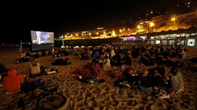 People watch a movie on a beach at night in Marseille, France, on September 13, 2017. A woman attacked four tourists with acid at a train station in Marseille, injuring two.(Reuters)